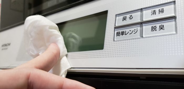 電子レンジの液晶画面を拭いている